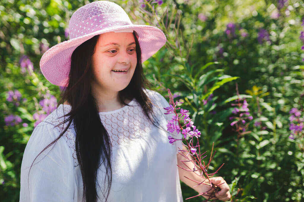 Happy disabled girl outside smiling holding flowers