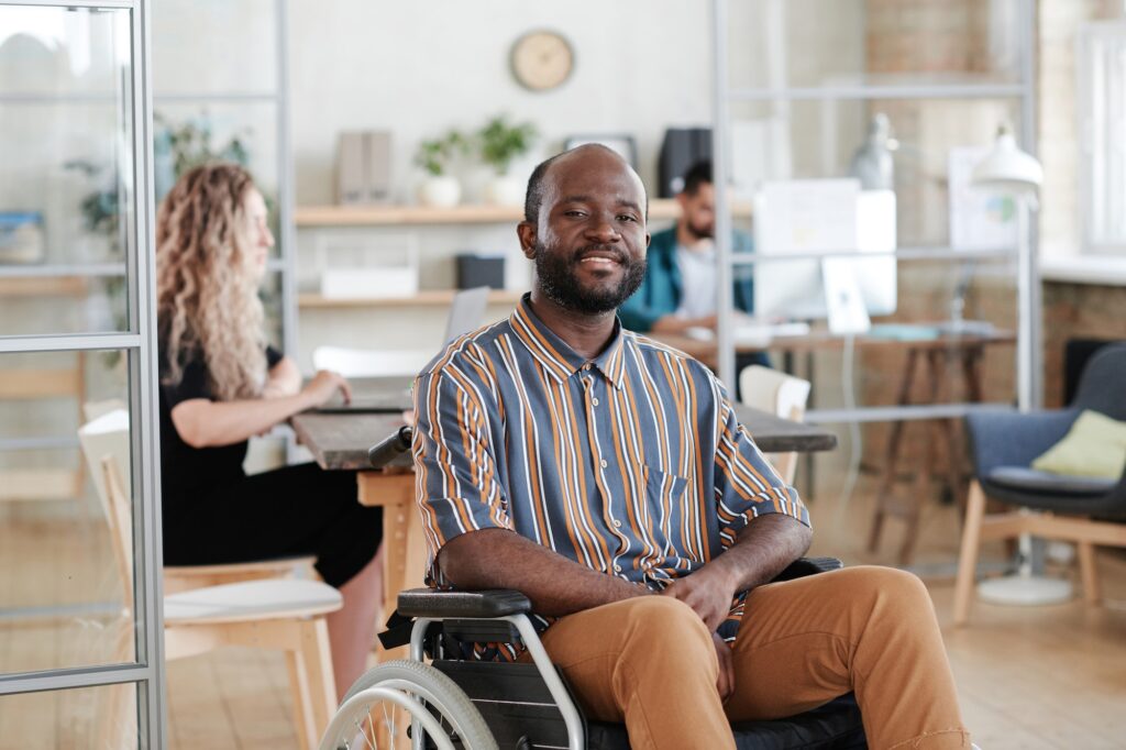 Happy disabled man in wheelchair smiling at camera