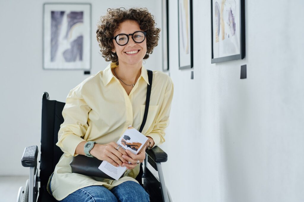 Happy disabled woman in wheelchair smiling at camera
